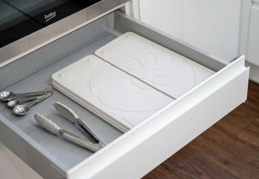 Space saving dish drying mat stored flat inside a kitchen drawer